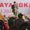 Lombok Barat, NTB – Kepolisian Republik Indonesia (Polri) merayakan ulang tahunnya yang ke-79 pada 1 Juli 2025. Di Lombok Barat, peringatan Hari Bhayangkara kali ini selain dengan menggelar upacara, juga ditandai dengan acara tasyakuran yang penuh makna. Menegaskan kembali komitmen Polri untuk terus meningkatkan kualitas pelayanan kepada masyarakat. Pada Selasa (1/7/2025), suasana di bencingah kantor Bupati Lombok Barat tampak semarak dengan kehadiran para pejabat dan tokoh masyarakat. Acara Tasyakuran Hari Bhayangkara ke-79 ini digelar di Jalan Soekarno-Hatta, Kelurahan Dasan Geres, Kecamatan Gerung, Kabupaten Lombok Barat, menjadi momentum penting. Untuk mempererat sinergitas antara Polri, TNI, pemerintah daerah, dan seluruh elemen masyarakat. Meningkatkan Pelayanan dan Memperkuat Sinergi Dalam sambutannya yang penuh semangat, Kapolres Lombok Barat, AKBP Yasmara Harahap, S.I.K., menyampaikan bahwa Hari Bhayangkara ke-79 mengusung tema ‘Polri untuk Masyarakat’. Menurutnya, tema ini bukan sekadar slogan, melainkan sebuah amanah untuk terus berbenah. "Dalam rangka Hari Bhayangkara ke-79 tahun 2025 dengan tema Polri Untuk Masyarakat, tentunya kita harus meningkatkan kualitas diri sebagai insan Bhayangkara. Untuk melaksanakan pelayanan maksimal kepada masyarakat," ujar AKBP Yasmara. Ia menekankan pentingnya introspeksi diri dan peningkatan kinerja untuk memberikan pelayanan terbaik. "Polri tegak berdiri dan berkomitmen untuk menjadi lebih modern dan terpercaya," tambahnya. Menurut Kapolres, semua upaya ini bertujuan utama untuk menjaga stabilitas keamanan dan ketertiban masyarakat (kamtibmas) di Provinsi NTB agar tetap kondusif. Ia juga menjelaskan bahwa rangkaian kegiatan dalam rangka Hari Bhayangkara di Polres Lombok Barat sudah dimulai sejak awal Juni. Dengan berbagai kegiatan yang menyentuh langsung masyarakat. AKBP Yasmara Harahap juga menyampaikan rasa terima kasihnya kepada semua pihak yang telah mendukung tugas-tugas Polri. "Terima kasih kepada Bapak Bupati yang telah mendukung tugas-tugas kamtibmas. Tidak mungkin kami berjalan sendiri tanpa dukungan dari Pemda dan seluruh elemen masyarakat," tegasnya. Kolaborasi Pemerintah dan Polri untuk Pelayanan Optimal Senada dengan Kapolres, Bupati Lombok Barat, H. Lalu Ahmad Zaini, S. Si., M.T., juga memberikan apresiasi setinggi-tingginya kepada jajaran kepolisian. Dalam pernyataannya, Bupati mengucapkan selamat Hari Bhayangkara dan menekankan pentingnya sinergi antara pemerintah daerah dan Polri. "Atas nama Pemerintah Kabupaten Lombok Barat, kami menyampaikan dirgahayu Kepolisian," kata Bupati Lalu Ahmad Zaini. "Sinergitas dan kolaborasi akan terus kita tingkatkan agar pelayanan kepada masyarakat akan terus dapat dioptimalkan,” imbuhnya. Pernyataan ini menunjukkan komitmen kuat dari pemerintah daerah untuk terus bekerja sama dengan Polri demi kesejahteraan dan keamanan masyarakat Lombok Barat. Momen Kebersamaan dan Apresiasi Setelah sambutan, acara dilanjutkan dengan momen simbolis pemotongan kue dan tumpeng. Kapolres Lombok Barat bersama Ibu Ketua Bhayangkari, Bupati Lombok Barat, perwakilan Dandim 1606, Wakil Bupati, Sekda, dan Ketua DPRD secara bersama-sama melakukan pemotongan tumpeng, melambangkan kebersamaan dan rasa syukur. Kemeriahan acara juga terasa saat pembacaan dan penyerahan hadiah bagi para pemenang lomba-lomba yang diselenggarakan dalam rangka memeriahkan Hari Bhayangkara ke-79. Berbagai lomba tersebut tidak hanya menjadi ajang silaturahmi, tetapi juga menunjukkan partisipasi aktif masyarakat dalam perayaan hari jadi korps Bhayangkara. Peringatan Hari Bhayangkara ke-79 ini menjadi momentum refleksi bagi seluruh jajaran Polres Lombok Barat untuk terus berbenah dan meningkatkan kualitas diri. Turut hadir pula dalam acara ini, Ketua Cabang Bhayangkari Lombok Barat, Ny. Citra Yasmara, bersama jajaran pengurus. Serta perwakilan dari Kodim 1606 Mataram, Letkol Inf. Abdul Haris S.H. M.H. Selain itu, hadir pula Wakil Bupati Lombok Barat, Hj. Nurul Adha, S.THI, Sekda Kabupaten Lombok Barat, H. Ilham S.Pd M.Pd., Ketua DPRD Kabupaten Lombok Barat, Lalu Ivan Indaryadi, serta perwakilan dari Pengadilan Negeri Mataram dan Kejaksaan Negeri Mataram. Kehadiran para pimpinan OPD, tokoh agama, tokoh masyarakat, dan tokoh adat menunjukkan soliditas dukungan terhadap tugas-tugas kepolisian.